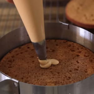The image shows the process of frosting dulce de leche cake