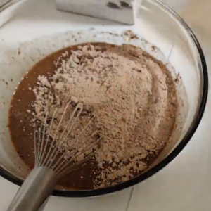 The image shows stirring of ingredients of Ghirardelli Brownies