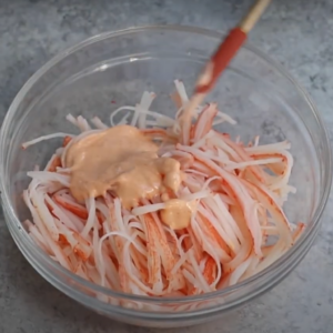 this image shows crab meat strips tossed in this delicious sauce