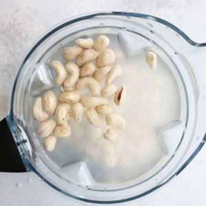 The image shows cashews and oat milk in the blender for oat milk ice cream