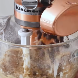 this image shows the process of adding chocolate chips to the mixture of edible cookie dough