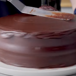 This image shows spreading frosting over the cooled cake.