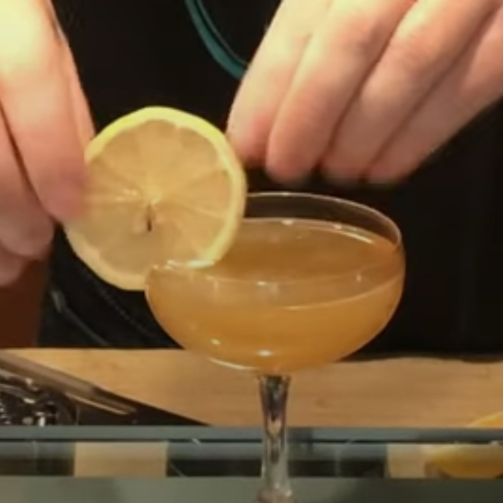The image shows honey bee cocktail serve in a glass
